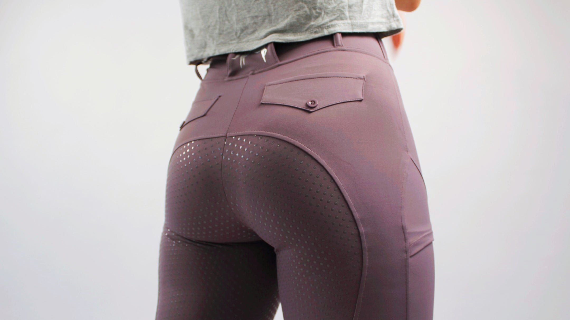 back view of plum fusion tights, highlighting silicone seat and back pockets