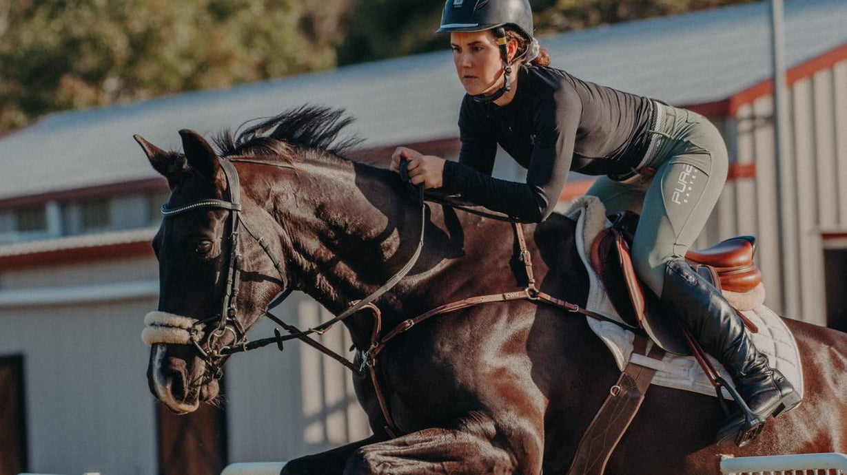 Showjumping picture of girl and her horse in Motion Base Layer Black and Fusion Tights Sage