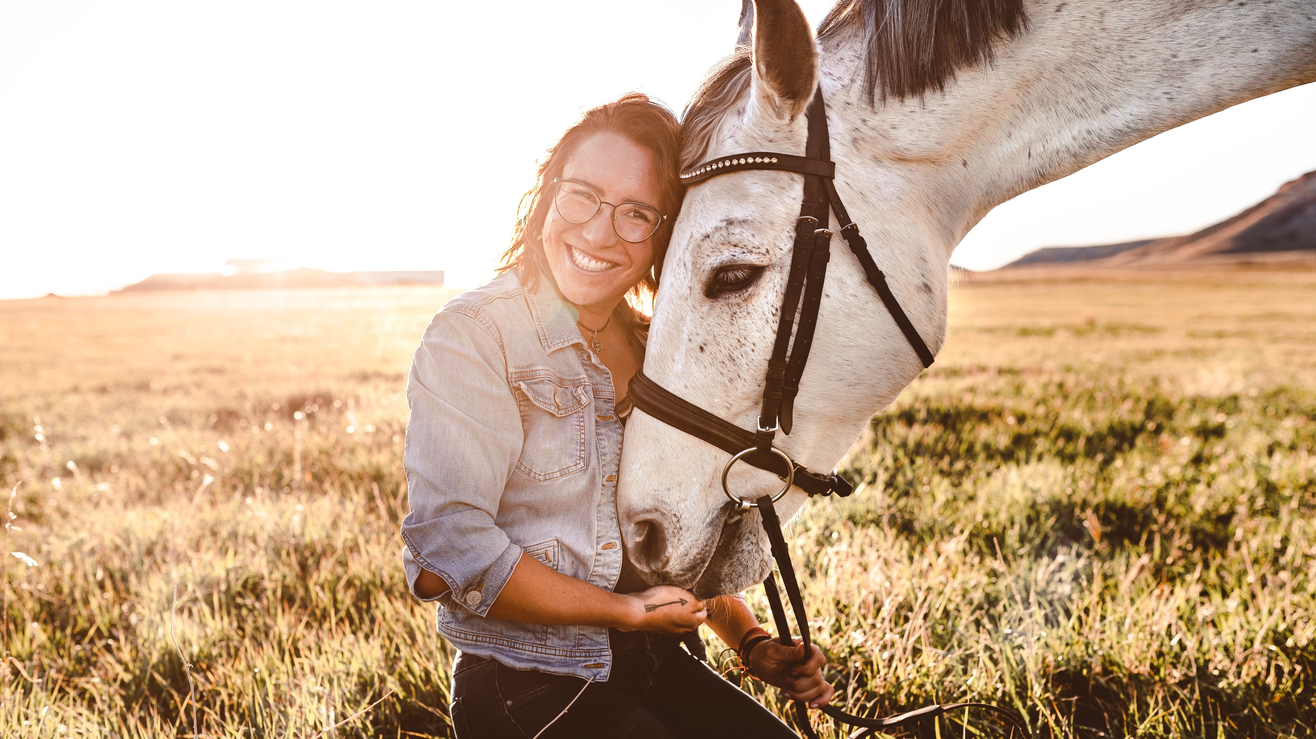 horse and rider in field with sun shining and lots of smiles