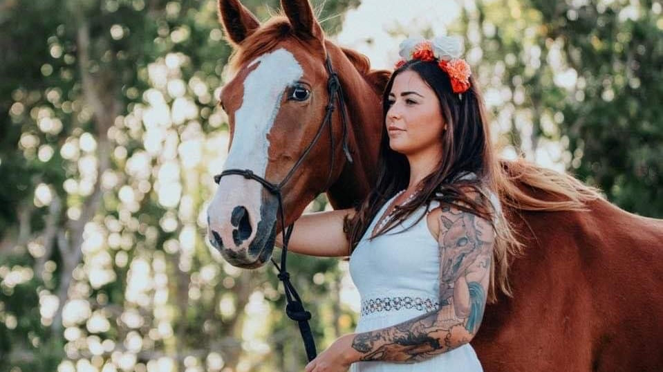 beautiful photo of dressed up tattoed girl holding her horse