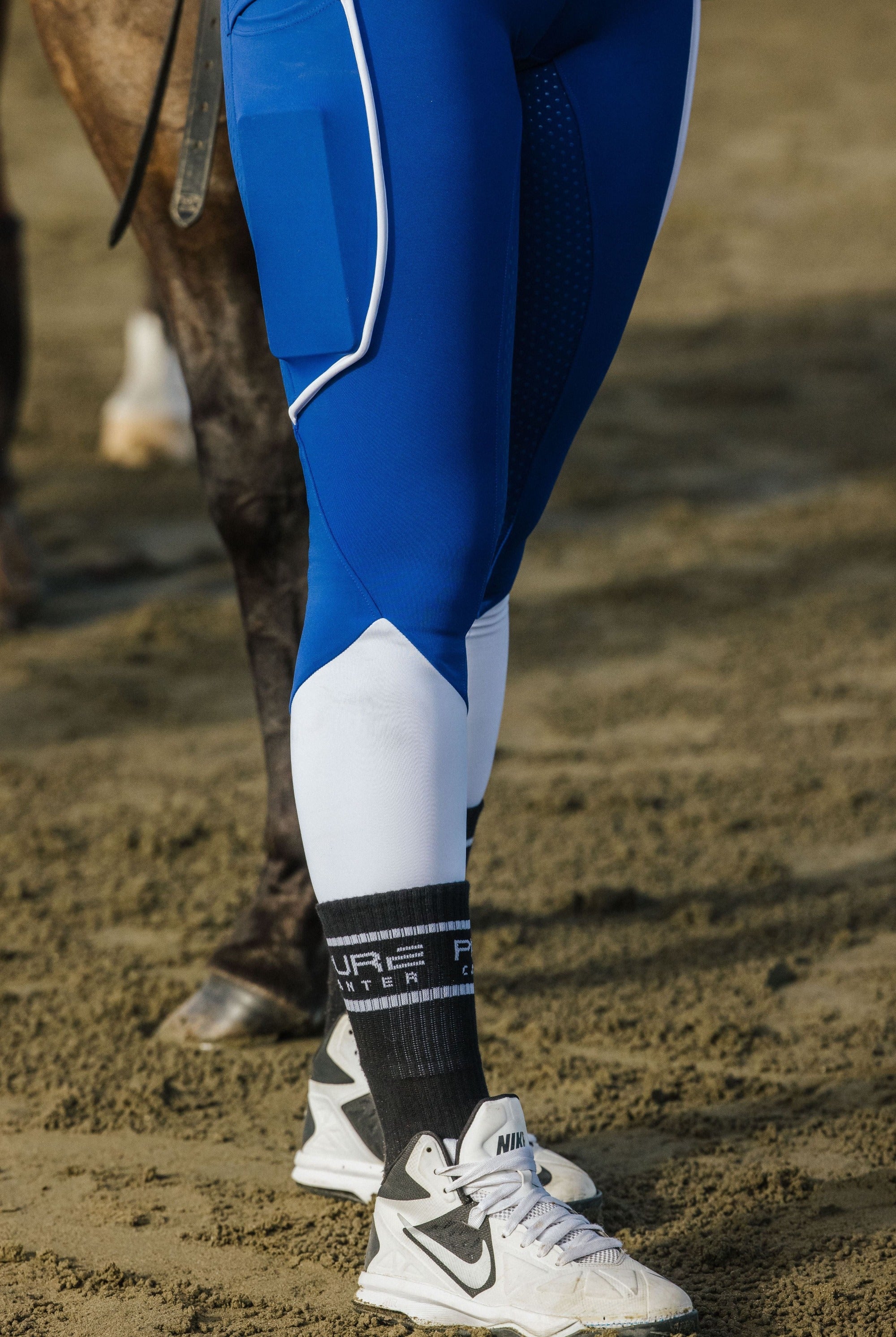 leg shot of royal blue riding tights showing white trim detail on tights as well as bottom white colour offset
