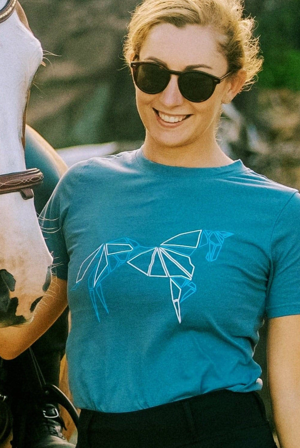 front view of girl and horse in a dusty blue tshirt