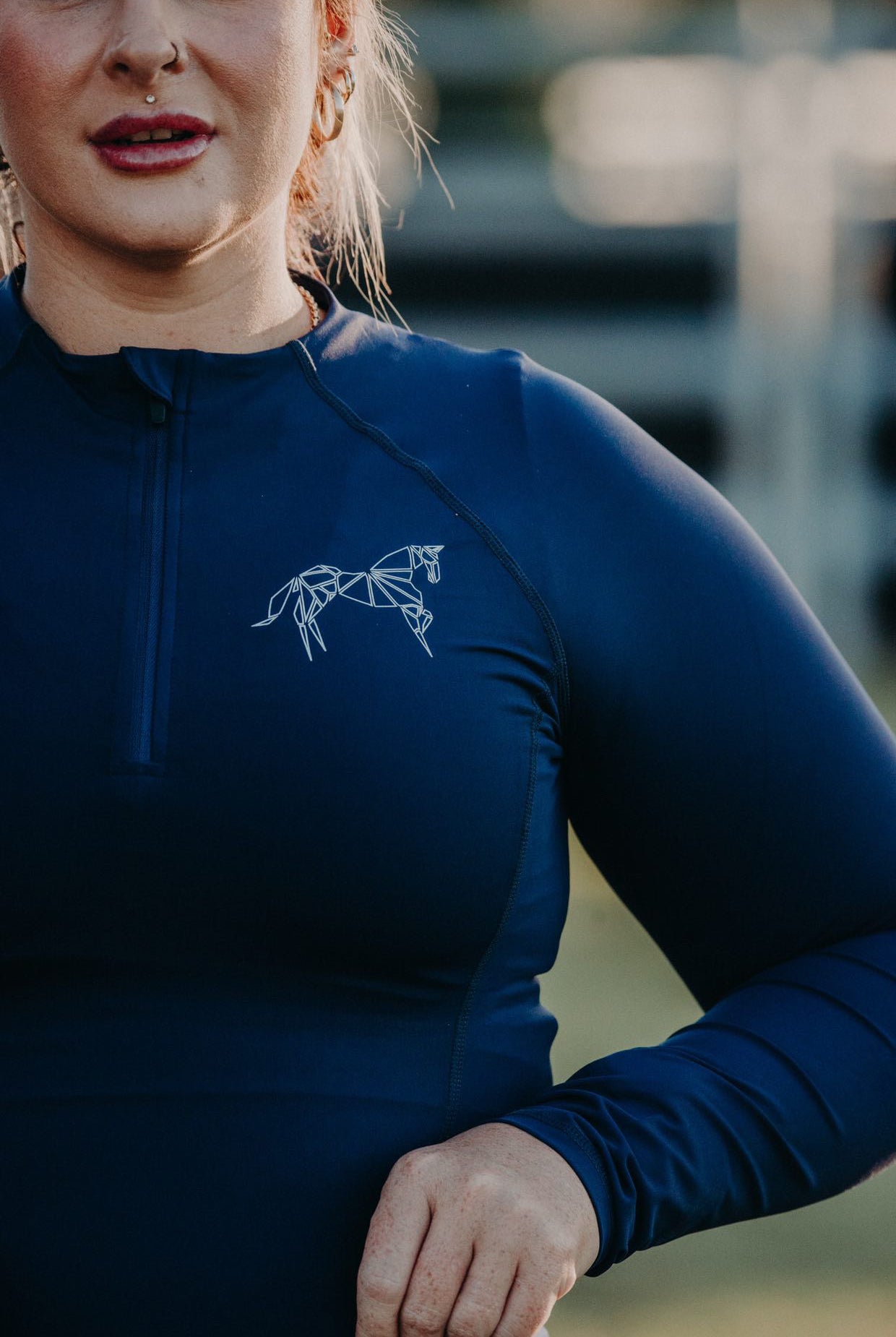 A close-up photograph of an equestrian base layer's fabric texture. The lightweight and stretchy material ensures freedom of movement, while the flatlock seams minimize friction for a chafe-free experience.